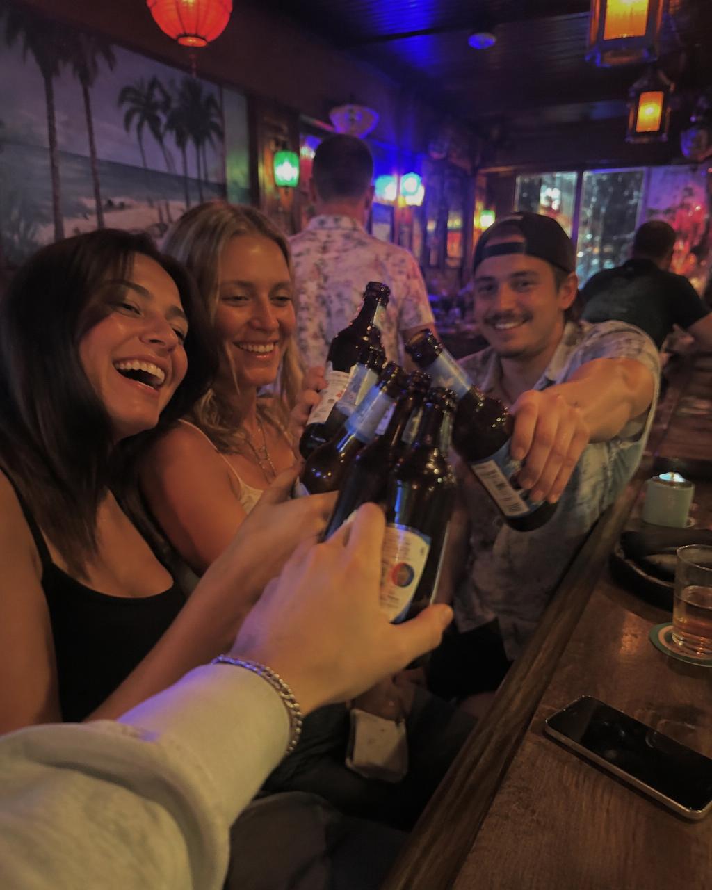 Friends clinking drinks at a neon-lit St. Pete dive bar